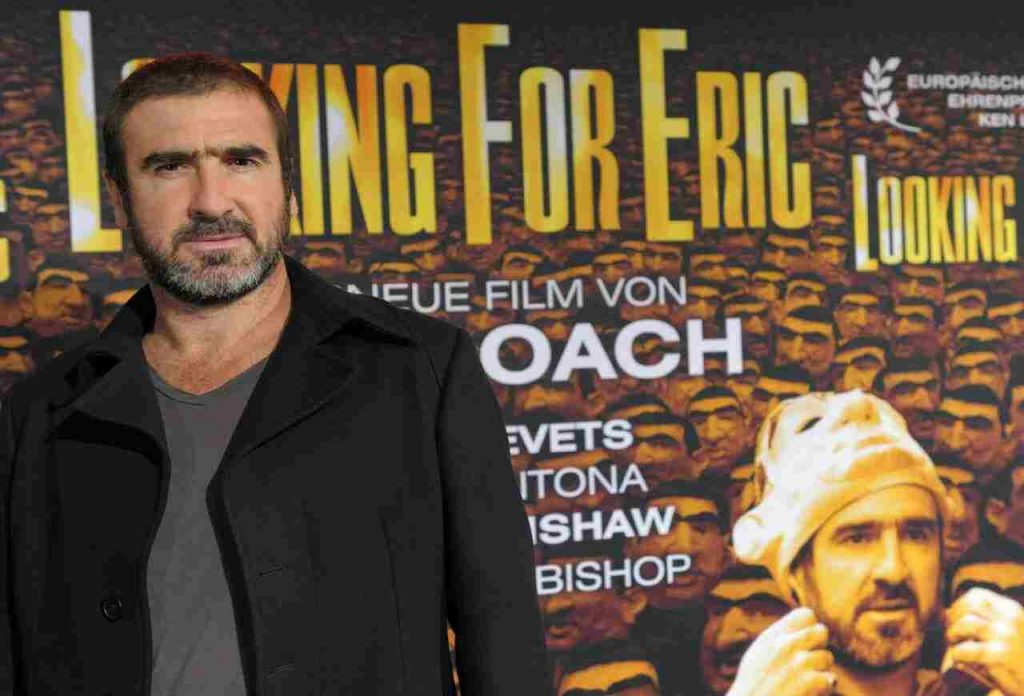 Eric Cantona e la locandina del suo più noto film 'Looking for Eric' - 'Il mio amico Eric'