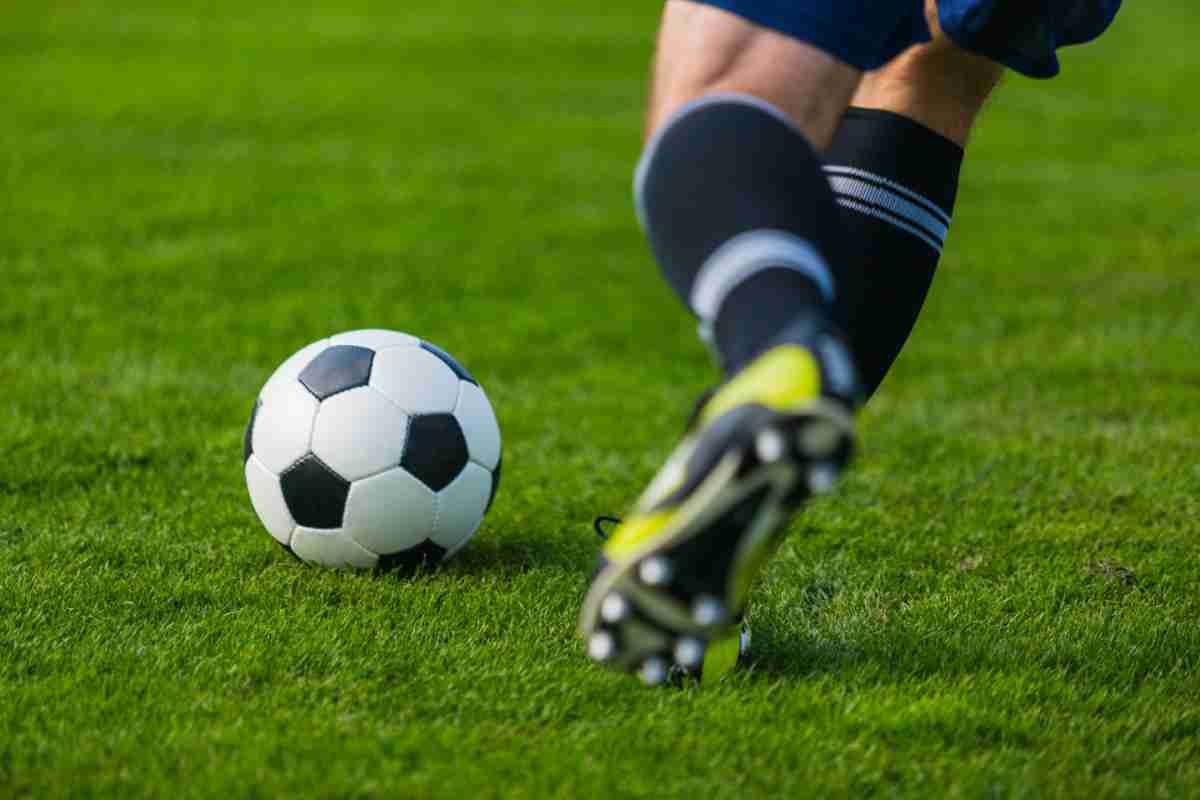 Giocatore su prato che sta per dare un calcio al pallone